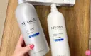 A-Hand-Holding-Nexxus-Shampoo-and-Nexxus-Conditioner-on-a-Table.webp