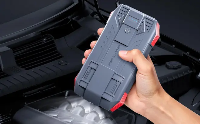 A-Person-Holding-a-Tstiti-Car-Battery-Jump-Starter.webp