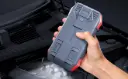 A-Person-Holding-a-Tstiti-Car-Battery-Jump-Starter.webp